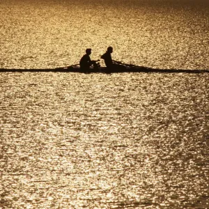 Print of rowers silhouetted in rising sun over Sukhana Lake