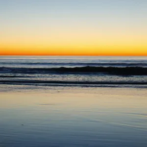 A lone surfer heads home after surfing past sunset in Leucadia