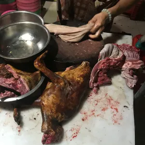 A man cuts dog meat at a dog meat restaurant ahead of local dog meat festival in Yulin