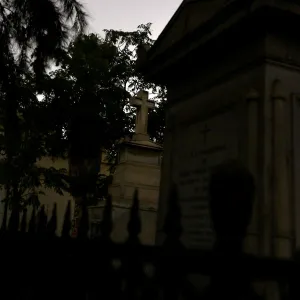 A man watches a movie in a cemetery as part of Ghost Tour heritage circuit, in Santiago