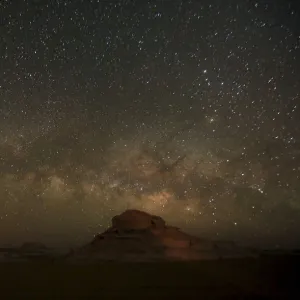 The Milky Way is seen in the night sky over rocks in the White Desert north of the