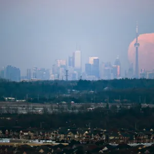 The moon rises over the Toronto city skyline as seen from Milton, Ontario