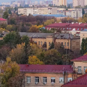 The morning sun shines on buildings and autumnal trees in an unusually hot autumn in Kiev