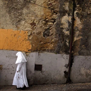 A nun walks at the Alfama neighborhood in Lisbon