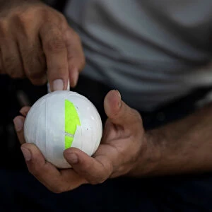 A Pakistani man living in Greece wraps a tennis ball in electrical tape before a tape-ball