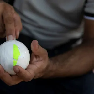 A Pakistani man living in Greece wraps a tennis ball in electrical tape before a tape-ball