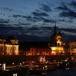 People stroll along the embankment of the Elbe river in Dresden