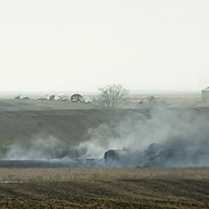 Smoke from the wreckage of several oil tanker cars that derailed in a field near Heimdal