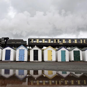 A steam train passes beach huts on Goodrington Sands in Paignton