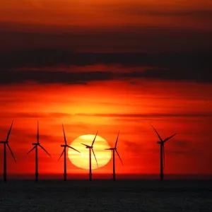 The sun sets behind the Burbo Bank wind farm near New Brighton