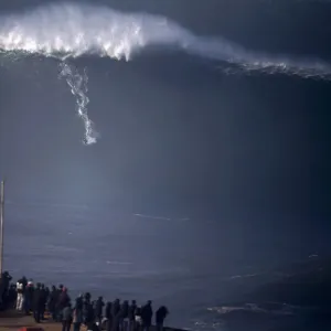 A surfer drops in on a large wave at Praia do Norte, in Nazare