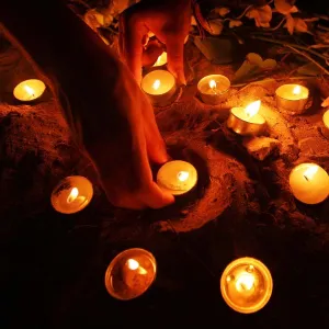 Tourists arrange oil lamps during candle light vigil ceremony on Thai island of Phi Phi