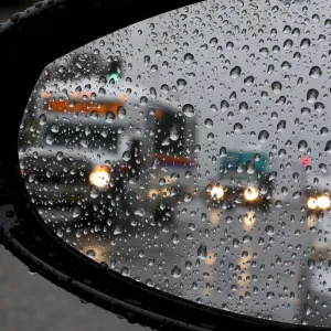 Traffic is reflected in a car mirror as heavy rain falls in San Juan Capistrano