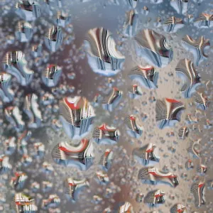 Water droplets on a window reflect Housing Development Board apartment flats in Singapore