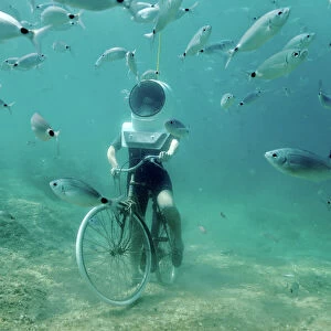 A woman dives and pretends to ride a bike in Underwater Park in Pula