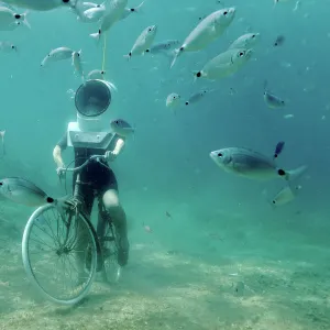 A woman dives and pretends to ride a bike in Underwater Park in Pula