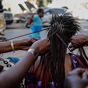A woman gets her hair plaited at the Medina in the capital Dakar