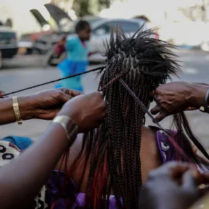 A woman gets her hair plaited at the Medina in the capital Dakar