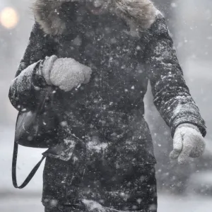 A woman walks through snow in London