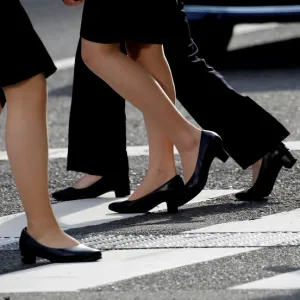 Women in high heels walk at a business district in Tokyo