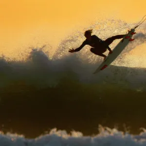 Young surfer sails his board off a wave as large swells hit the California coastline