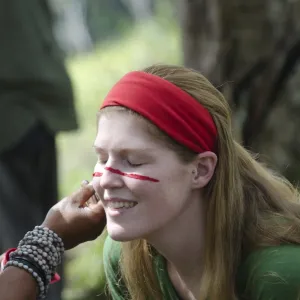 Tourist having her face painted at Sing-sing - The Paiya Show in Western Highlands