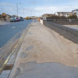 Sand blown from beach and dunes onto road and pavement in seaside resort town, Lytham St. Anne's, Lancashire, England, january