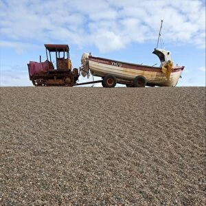 Tractor with landed fishing boat on shingle beach, Weybourne, Norfolk, England, august