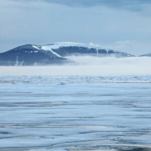View of coastal ice floes, with fog covered mountains in background, Spitsbergen, Svalbard, september