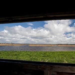 View of lagoon and reedbed habitat through hide window, Blacktoft Sands RSPB Reserve, East Yorkshire, England, April