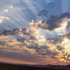 Africa, Namibia, Namib-Naukluft Park. Panoramic of God beams over desert at sunset