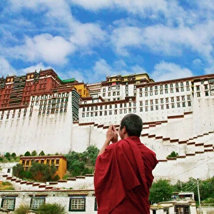 China, Tibet, Lhasa, Tibetan monk with Potala Palace (MR)