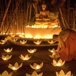 Monks lighting khom loy candles and lanterns for Loi Krathong festival