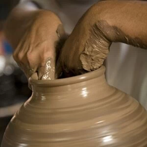 Nicaragua, Catarina. Potters hands creating clay pottery on spinning wheel