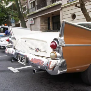 A Studebaker Silver Hawk Classic Car parked on a street, painted in cream white and brown