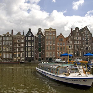 A tour boat at Rederij Plas dock on a canal lined with colorful gabled homes