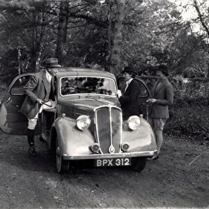 Three people getting into an old car, possibly a Standard, November 1936