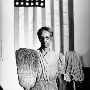 AMERICAN GOTHIC, 1942. Ella Watson, a US Government Chairwoman. Photograph by Gordon Parks, 1942