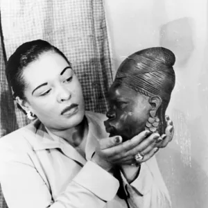 BILLIE HOLIDAY (1915-1959). American jazz singer, holding an African sculpture. Photographed by Carl Van Vechten, 1949