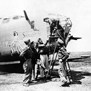 Crew of the B-24 bomber named Snow White, of the U. S. Army 9th Air Force at a base in the Libyan desert during World War II. Photograph by Nick Parrino, April 1943