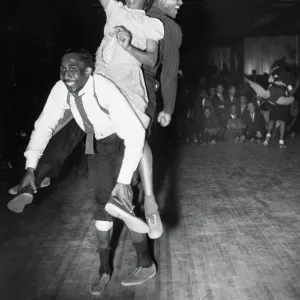 Three dancers dancing the Harlem conga, a blend of the lindy hop, conga and the Australian kangaroo hop, at a dance hall in Harlem, New York, 1941