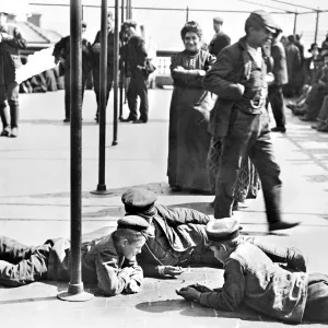 Detained immigrants awaiting approval to enter the United States, amusing themselves on the rooftop of the main building at Ellis Island, New York City. Photograph, c1907