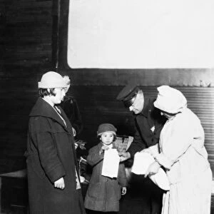 ELLIS ISLAND, 1921. A matron of the Health Department and a policeman examining