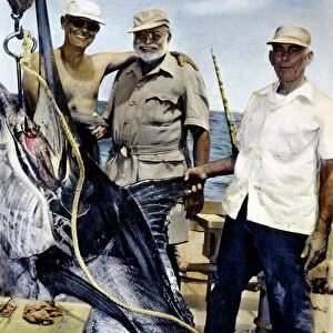 ERNEST HEMINGWAY (center) with Cuban sportsman Elicio Arguelles, Jr. and fishing-boat captain Gregorio Fuentes in Cuba during the filming of The Old Man and the Sea in 1956