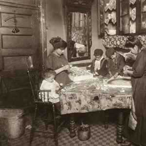HINE: HOME INDUSTRY, 1911. A family making flowers in a unsanitary tenement apartment