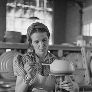POTTERY MAKING, 1940. A woman working at a pottery wheel, possibly at the Indian
