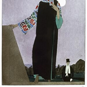 WOMENs FASHION, 1921. A woman wearing an evening coat designed by Paul Poiret