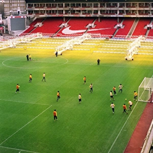 The Arsenal team train on the pitch at Highbury