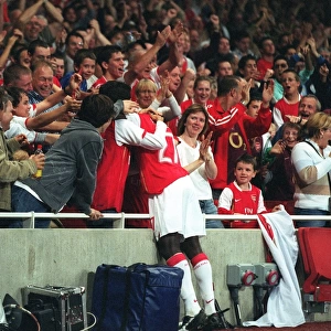Emmanuel Eboue celebrates with the fans after Thierry Henrys goal for Arsenal