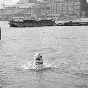 A Dalek emerges from the river Thames at the jetty near Battersea Church Road